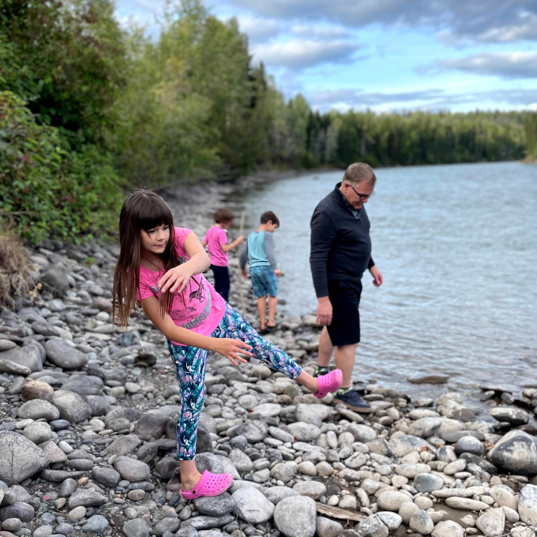 Jim Gibbon and children skipping rocks on a lake