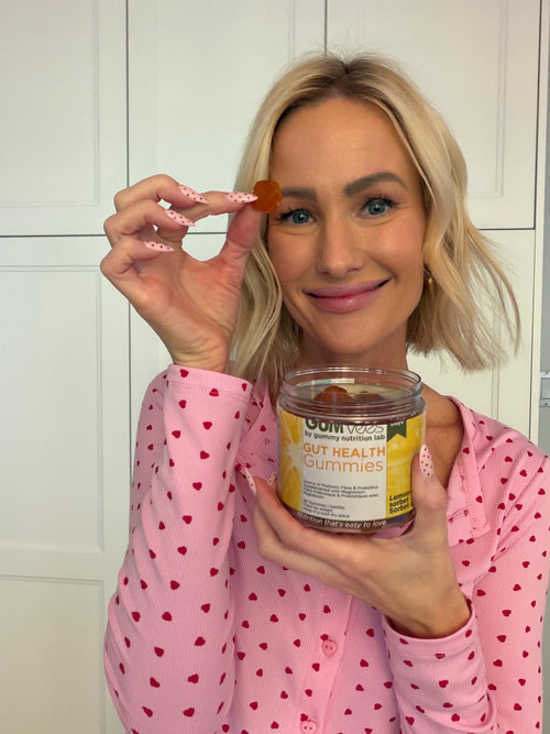 A GUMvees customer smiling and holding a jar of gummies