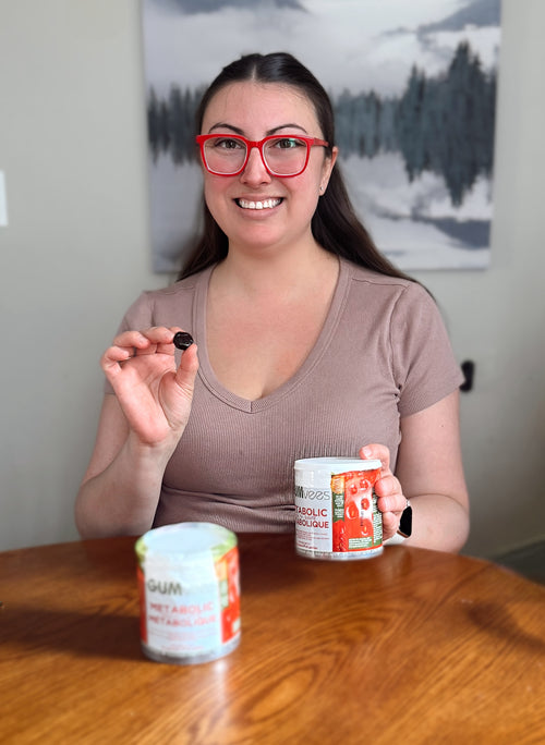 A GUMvees customer at her table with a jar, holding up a gummy