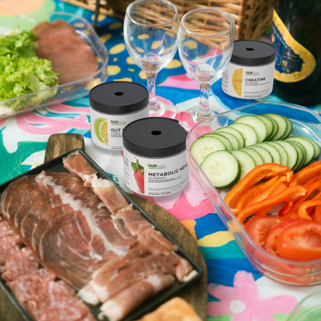 gum'vees metabolic health, creatine, and gut health sit on a colourful picnic blanket surrounded by a picnic spread of meats, veggies, and wine